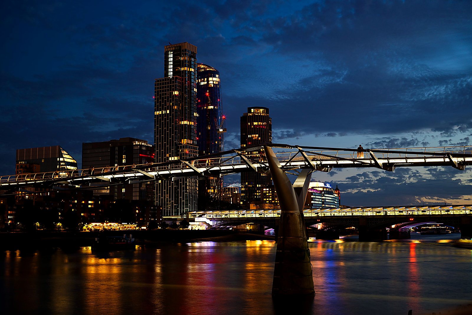 The City of London skyline and the Millennium Bridge at dusk